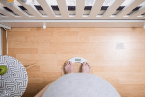 אישה בהריון עומדת על המשקל